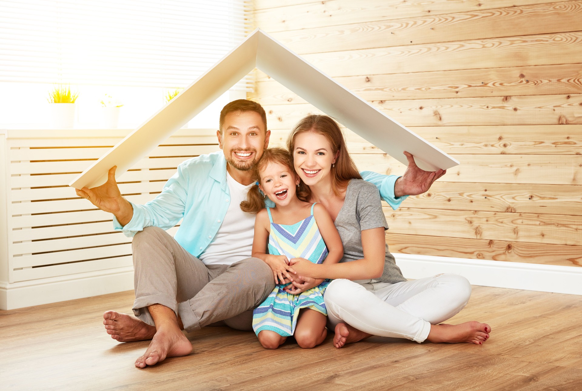 concept housing   young family. Mother father and child in new house with  roof